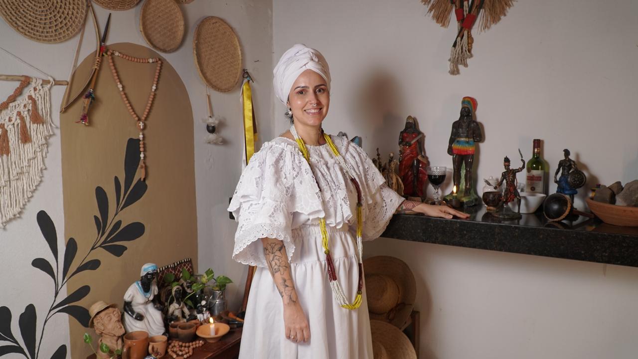 Mãe Núbia de Xangô vestida de branco no salão da Casa das Almas